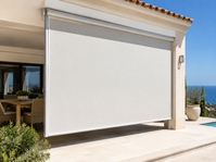 White vertical awning lowered across the open side of a terrace by the sea