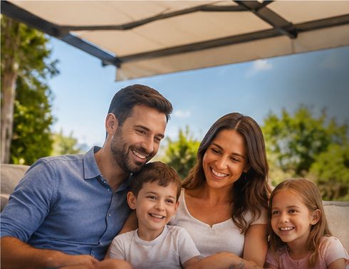 A smiling family sitting together under an open awning