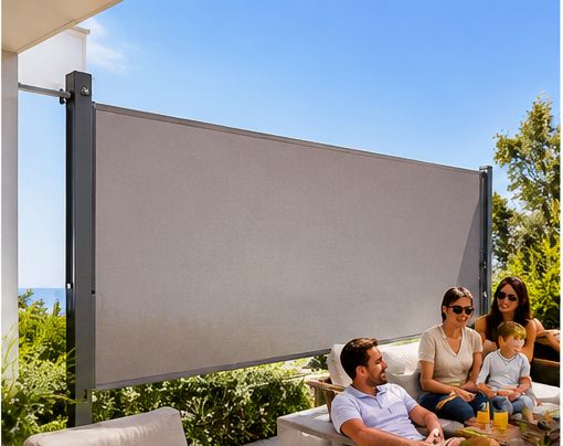 Grey lateral arm awning screening the side of a garden seating area